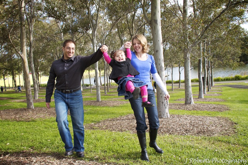 Little girls being swung in parents arms - family portrait photography sydney